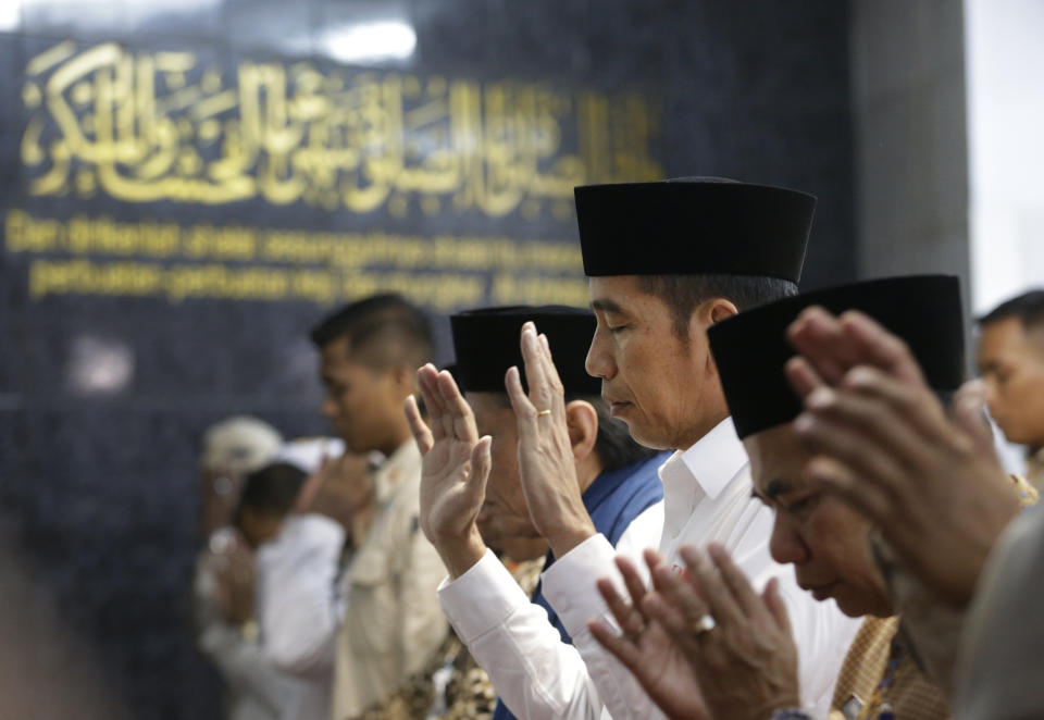 Indonesian President Joko Widodo, center, performs a Friday prayer at a mosque in the Tanah Tinggi neighborhood in Jakarta, Indonesia, Friday, July 26, 2019. Indonesian President Joko Widodo said in an interview Friday that he will push ahead with sweeping and potentially unpopular economic reforms, including a more business-friendly labor law, in his final term because he is no longer constrained by politics. (AP Photo/Dita Alangkara)