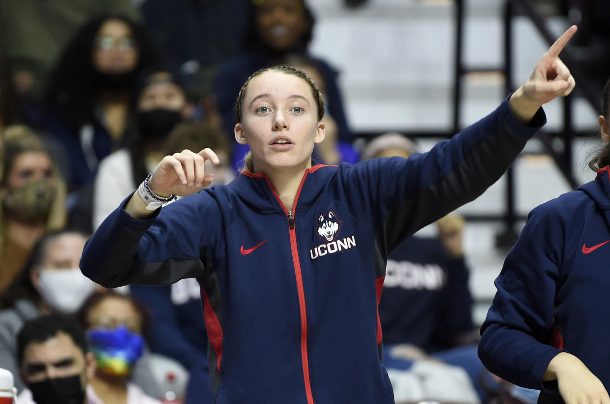 UNCASVILLE, CONNECTICUT - DECEMBER 19: Paige Bueckers #5 of the Connecticut Huskies cheers on her team during the game against the Louisville Cardinals in the Basketball Hall of Fame Women's Showcase at Mohegan Sun Arena on December 19, 2021 in Uncasville, Connecticut. (Photo by G Fiume/Getty Images)