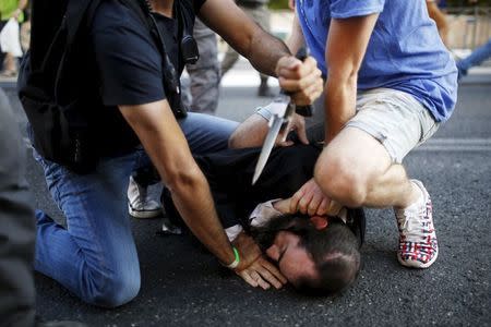 People disarm an Orthodox Jewish assailant shortly after he stabbed participants at the annual Gay Pride parade in Jerusalem July 30, 2015. REUTERS/Amir Cohen