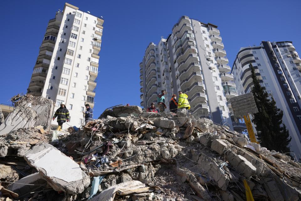 FILE - Emergency teams search for people in the rubble of a destroyed building in Adana, southern Turkey, Tuesday, Feb. 7, 2023. The 2011 quake, tsunami and nuclear meltdown in northern Japan provides a glimpse of what Turkey and Syria could face in the years ahead. No two events are alike, but the recent disaster resembles Japan's in the sheer enormity of the psychological trauma, of the loss of life and of the material destruction. (AP Photo/Hussein Malla, File)