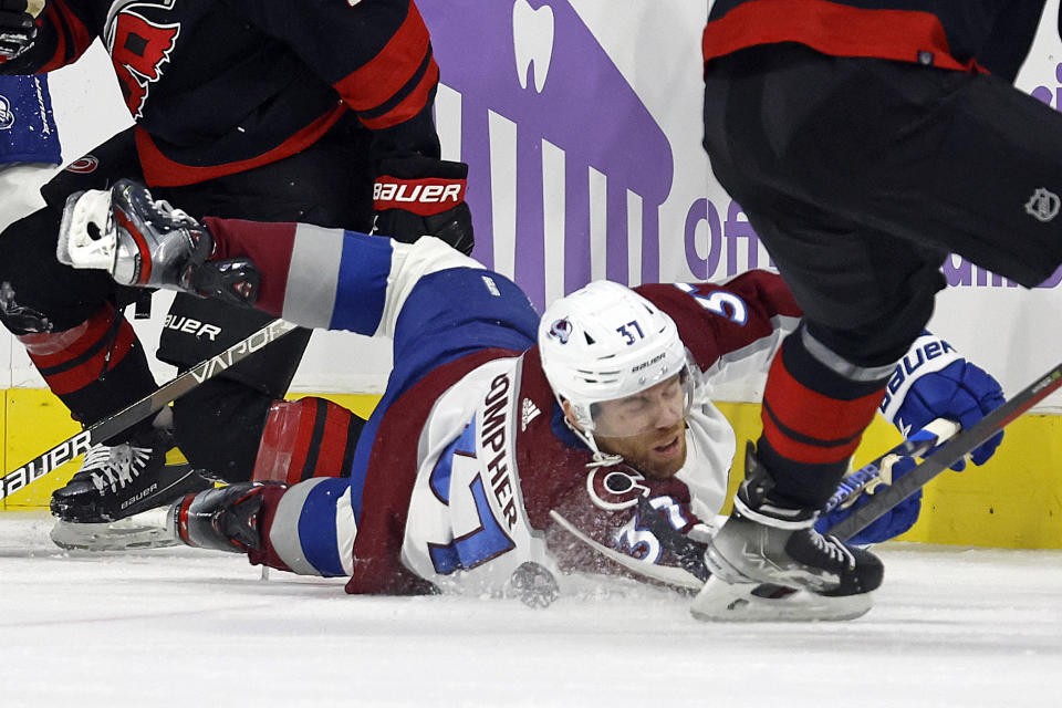 Colorado Avalanche's J.T. Compher (37) chases the puck down to the ice during the first period of an NHL hockey game against the Carolina Hurricanes in Raleigh, N.C., Thursday, Nov. 17, 2022. (AP Photo/Karl B DeBlaker)