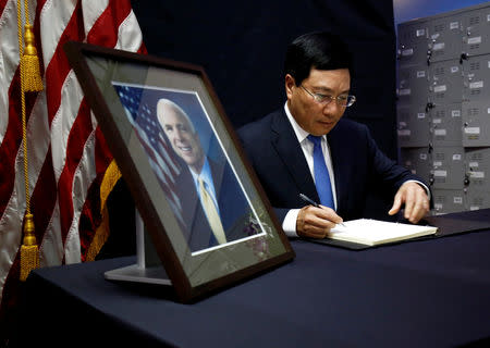 Vietnam's Deputy Prime Minister and Foreign Minister Pham Binh Minh writes in a condolence book near a portrait of U.S. Senator John McCain (R-AZ) about his death at the U.S. embassy in Hanoi, Vietnam August 27, 2018. REUTERS/Kham