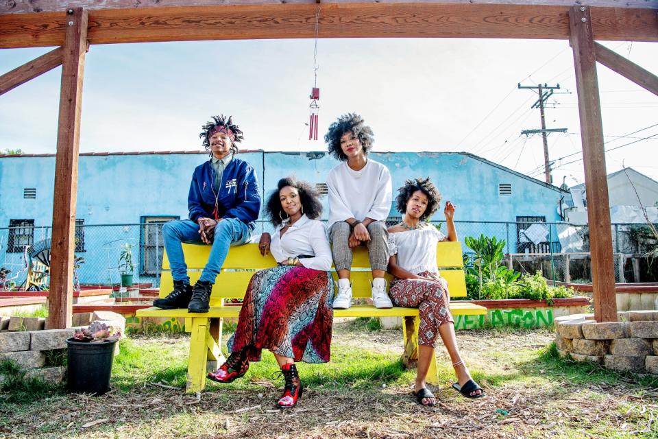 Four people pose at the Compton Community Garden.