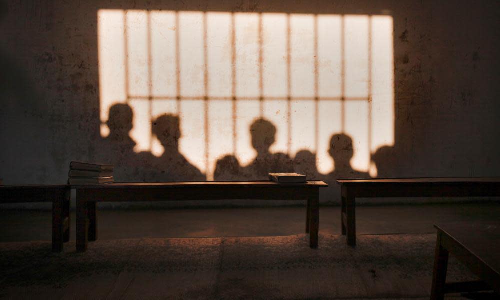 The shadows of schoolboys are seen on a classroom wall in Karachi