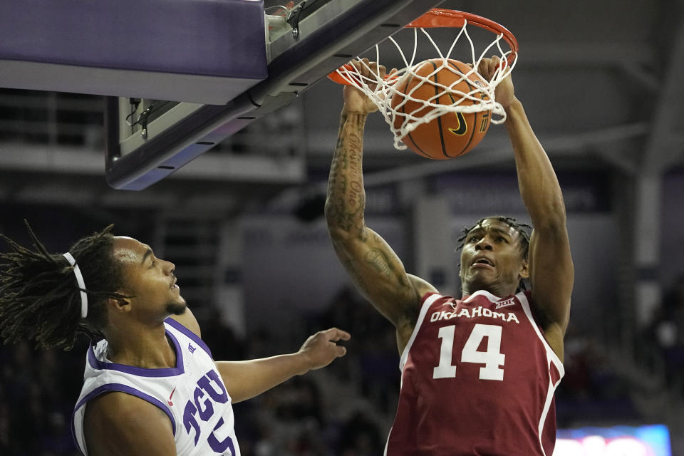 Oklahoma forward Jalon Moore (14) scores against TCU forward Chuck O'Bannon Jr. (5) during the first half of an NCAA college basketball game in Fort Worth, Texas, Wednesday, Jan. 10, 2024. (AP Photo/LM Otero)