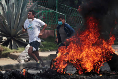 Demonstrators run past a burning barricade as they take part in a protest over a controversial reform to the pension plans of the Nicaraguan Social Security Institute (INSS) in Managua, Nicaragua April 21, 2018. REUTERS/Oswaldo Rivas