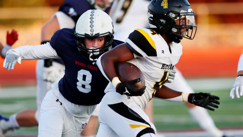 Roy’s DaeQwan Snider works to get away from Woods Cross’ Cash Sudbury as they play at Woods Cross High School on Friday, Sept. 22, 2023.