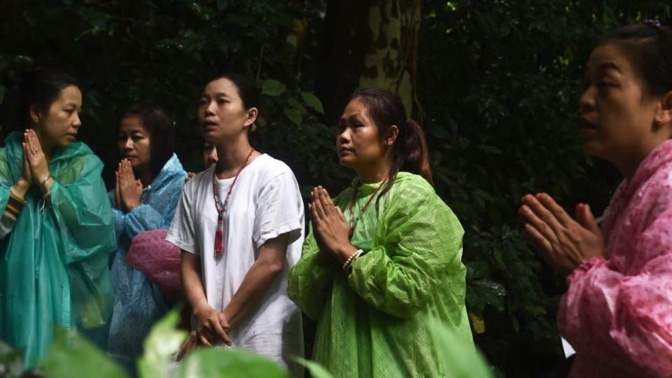 Relatives offer a prayer near Tham Luang cave