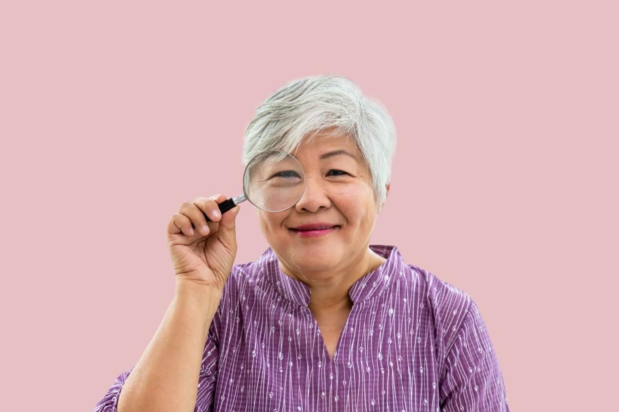 Portrait of senior woman female holding magnifying glass