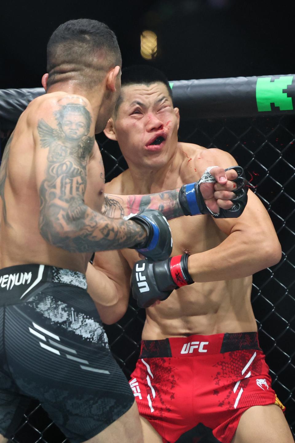 China's Li Jingliang (in red) is knocked out by Brazil's Carlos Prates during their Ultimate Fighting Championship (UFC) 305 men's welterweight event at Perth Arena in Perth on August 18, 2024. (Photo by COLIN MURTY/AFP) / -- IMAGE IS RESTRICTED TO EDITORIAL USE - STRICTLY NO COMMERCIAL USE -- (Photo by COLIN MURTY/AFP via Getty Images)