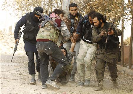 Free Syrian Army fighters carry a fellow fighter who was wounded during clashes with forces loyal to Syria's President Bashar al-Assad near Base 80 near Aleppo International airport, November 8, 2013. REUTERS/Molhem Barakat