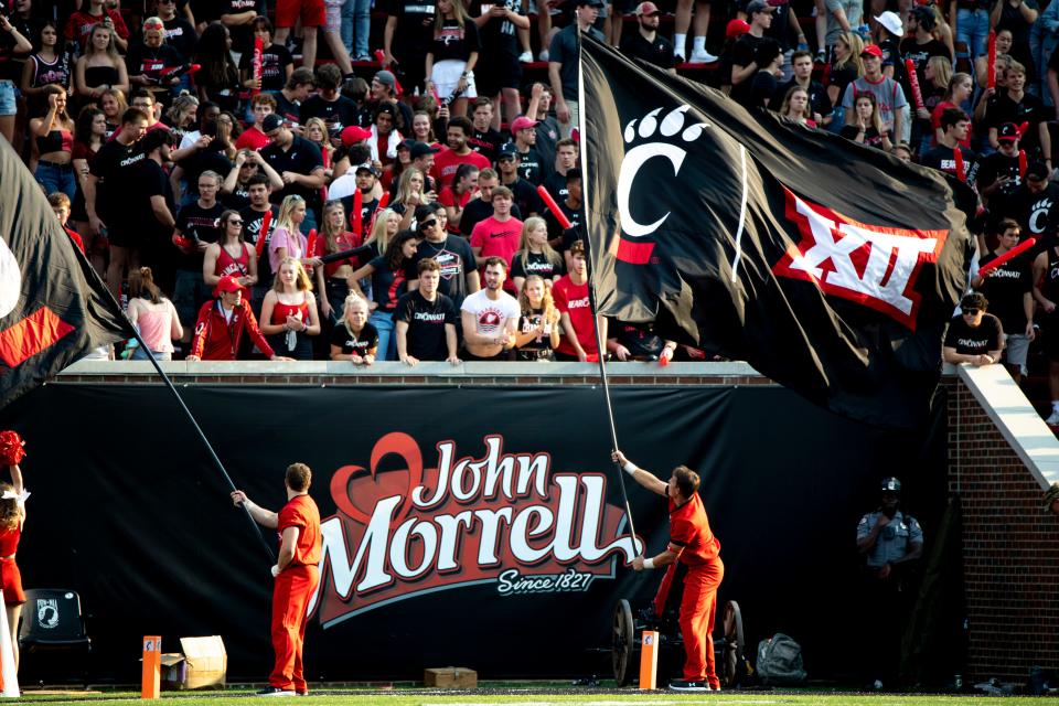 UC cheerleaders waive flags with the Big 12 logo during a football game against Murray State on Sept. 11, 2021, at Nippert Stadium. UC officially joins the league on July 1.