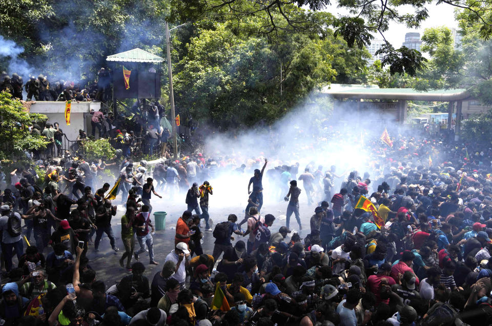 FILE - Police fire tear gas as protesters stormed the compound of Prime Minister Ranil Wickremesinghe demanding he resign after President Gotabaya Rajapaksa fled the country amid an economic crisis in Colombo, Sri Lanka, Wednesday, July 13, 2022. Since Sri Lanka defaulted in 2022, a half-million industrial jobs have vanished, inflation has pierced 50% and more than half the population in many parts of the country has fallen into poverty. (AP Photo/Eranga Jayawardena, File)