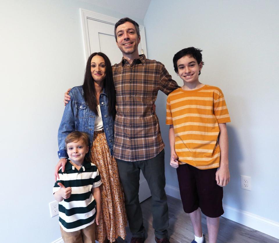 Alicia and Derek Harmon with their sons Grayson, left, and Gaberiel stand in Grayson's bedroom as part of the dedication day for their new home built by Habitat for Humanity Aug. 9, 2022.
