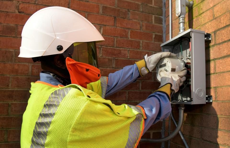 A utility worker installs a smart meter.