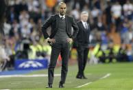 Bayern head coach Pep Guardiola, left, watches the Champions League semifinal first leg soccer match between Real Madrid and Bayern Munich at the Santiago Bernabeu stadium in Madrid, Spain, Wednesday, April 23, 2014. (AP Photo/Paul White)