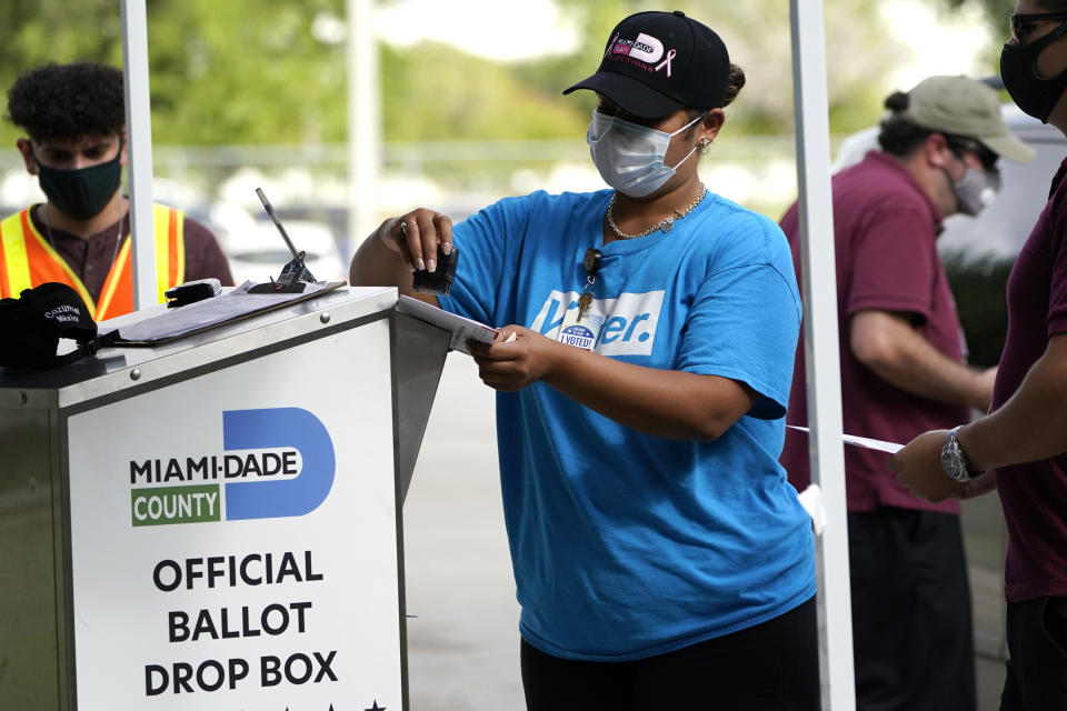 FILE - In this Monday, Oct. 26, 2020, file photo, an election worker stamps a vote-by-mail ballot dropped off by a voter before placing it in an official ballot drop box before at the Miami-Dade County Board of Elections in Doral, Fla. Ballot drop boxes were enormously popular during the 2020 election, with few problems reported. Yet they have drawn the attention of Republican lawmakers in key states who say security concerns warrant new restrictions. (AP Photo/Lynne Sladky, File)