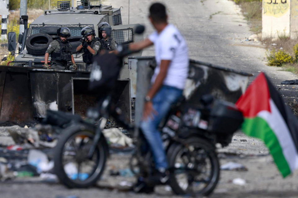 A Palestinian man faces Israeli troops during clashes in Ramallah near the Israeli settlement of Beit El on Oct. 20, 2023. (Jaafar Ashtiyeh / AFP - Getty Images)