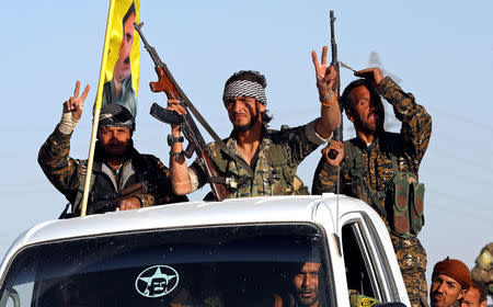 Fighters of Syrian Democratic Forces make the V-sign as their convoy passes in Ain Issa, Syria October 16, 2017. REUTERS/Erik De Castro