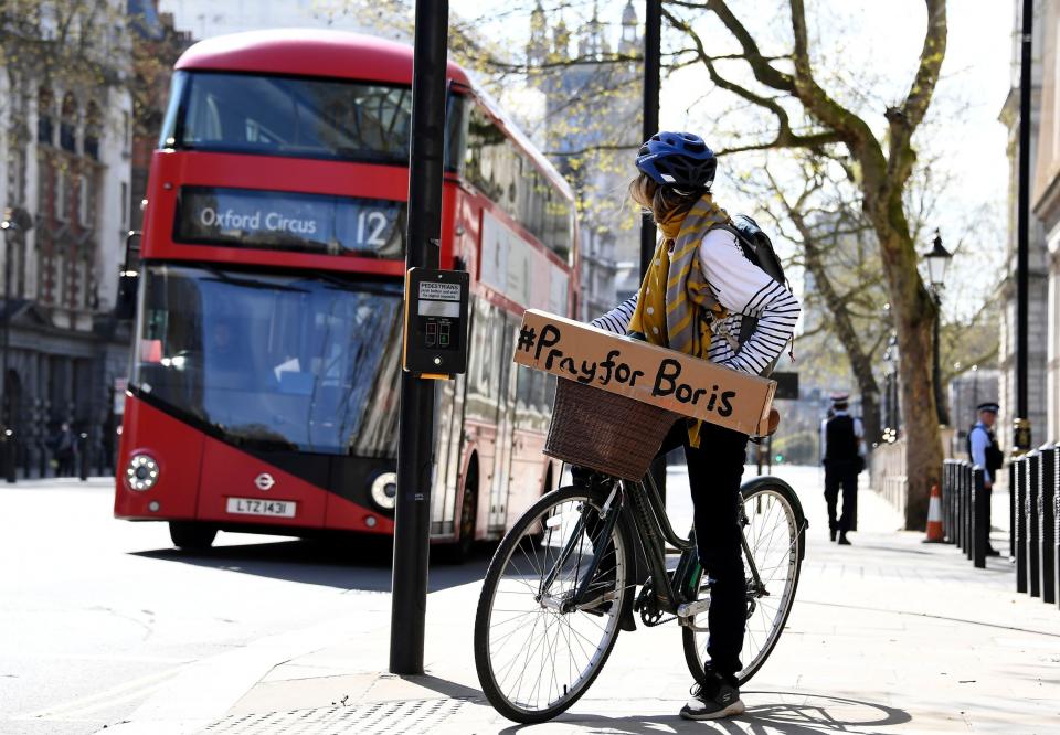 A woman in London shows her support for the Prime Minister as he remains in intensive care (AP)