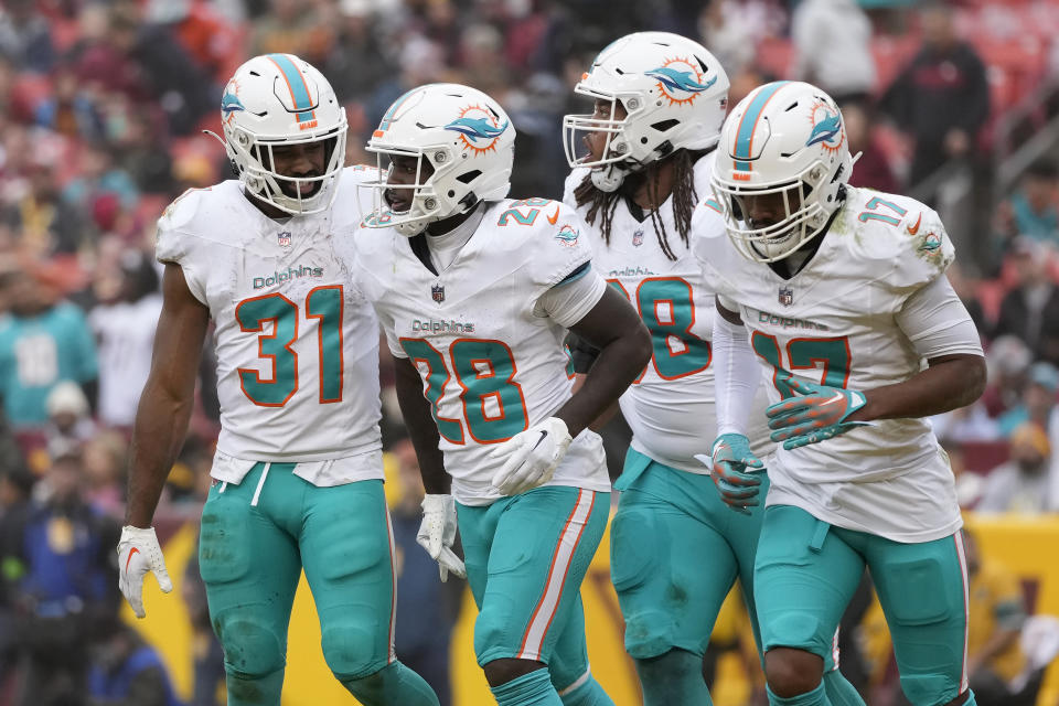 Miami Dolphins running back De'Von Achane (28) celebrates with running back Raheem Mostert (31), offensive tackle Robert Hunt, middle right, and wide receiver Jaylen Waddle (17) after scoring against the Washington Commanders during the second half of an NFL football game Sunday, Dec. 3, 2023, in Landover, Md. (AP Photo/Alex Brandon)