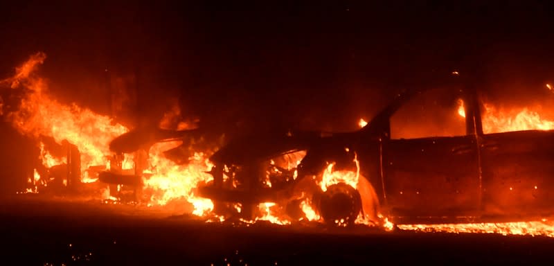 Cars destroyed by a wind-driven wildfire called the Saddle Ridge fire are seen in Porter Ranch