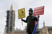 A pro EU protestor stands in parliament square in front of Parliament during the debate in the House of Commons on the EU (Future Relationship) Bill in London, Wednesday, Dec. 30, 2020.The European Union's top officials have formally signed the post-Brexit trade deal with the United Kingdom, as lawmakers in London get set to vote on the agreement. (AP Photo/Frank Augstein)