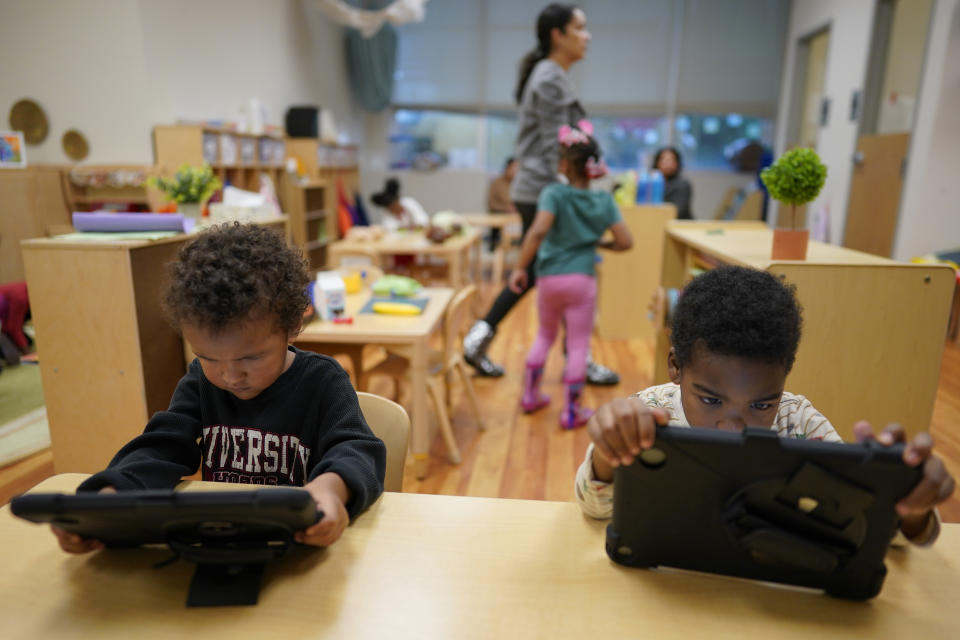 Children work on tablets during a preschool class at the Life Learning Center - Head Start, in Cincinnati, Tuesday, Nov. 21, 2023. A new plan from the Biden administration could significantly increase salaries for hundreds of low-paid early childhood teachers caring for the country's poorest children but might also force some centers to cut enrollment. (AP Photo/Carolyn Kaster)