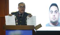 Director of the National Police, General Ney Aldrin Bautista Almonte, gives a press conference about the intellectual authors of the attack on former Boston Red Sox slugger David Ortiz, in front of an image of a man identified by authorities as Victor Hugo Gomez in Santo Domingo, Dominican Republic, Wednesday June 19, 2019. According to Bautista Almonte, Ortiz was shot by a gunman who mistook him for the real target, Sixto David Fernández, who was seated at the same table with the former baseball star on the night of June 9, and the attempted murder was ordered from the United States by Victor Hugo Gomez, Fernández's cousin and an associate of Mexico's Gulf Cartel. (AP Photo/Roberto Guzman)
