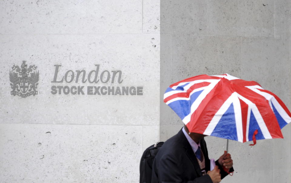 A worker shelters from the rain as he passes the London Stock Exchange in the City of London at lunchtime October 1, 2008.  REUTERS/Toby Melville/File Photo         GLOBAL BUSINESS WEEK AHEAD PACKAGE - SEARCH 'BUSINESS WEEK AHEAD APRIL 25'  FOR ALL IMAGES