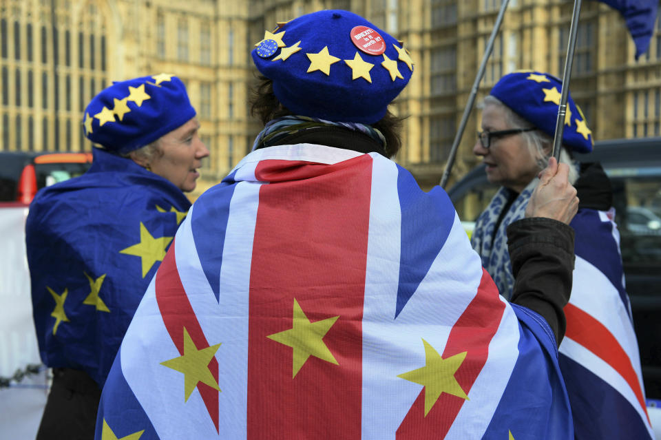 Anti-Brexit protestors wave flags outside Britain's parliament in London, Wednesday Feb. 13, 2019. British Prime Minister Theresa May urged lawmakers this week to give her more time to rework the Brexit agreement with the EU, with time ticking down to the March 29 deadline for a Brexit split from Europe. (Kirsty O'Connor/PA via AP)