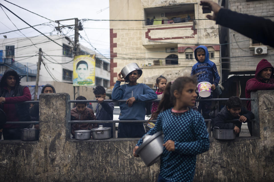 Palestinians line up for a free meal in Rafah, Gaza Strip, Friday, Feb. 16, 2024. International aid agencies say Gaza is suffering from shortages of food, medicine and other basic supplies as a result of the war between Israel and Hamas. (AP Photo/Fatima Shbair)