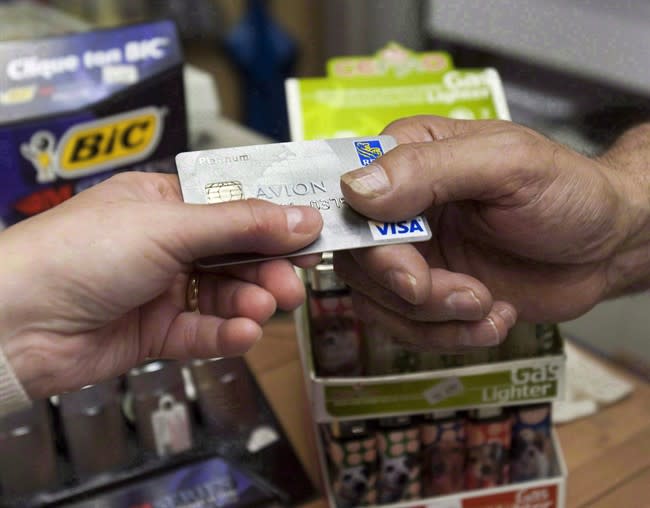 A consumer pays with a credit card at a store in Montreal on July 6, 2010. A new study shows that non-mortgage debt is continuing to rise in Canada, but at a relatively modest pace, and that low delinquency rates indicate Canadians have so far been able to handle the increase. THE CANADIAN PRESS/Ryan Remiorz