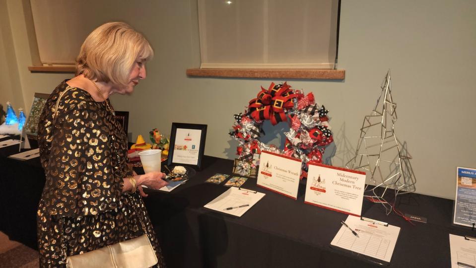 An attendee looks at one of the many unique Christmas trees auctioned off at the "Tree of Tidings" fundraiser Thursday night at the Panhandle-Plains Historical Museum in Canyon.