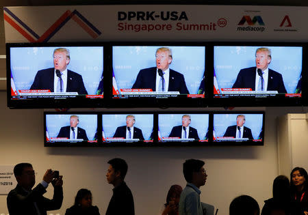 A TV news reports about U.S. President Donald Trump is projected on tv sets at a media center for the summit between the U.S and North Korea in Singapore, June 10, 2018. REUTERS/Kim Kyung