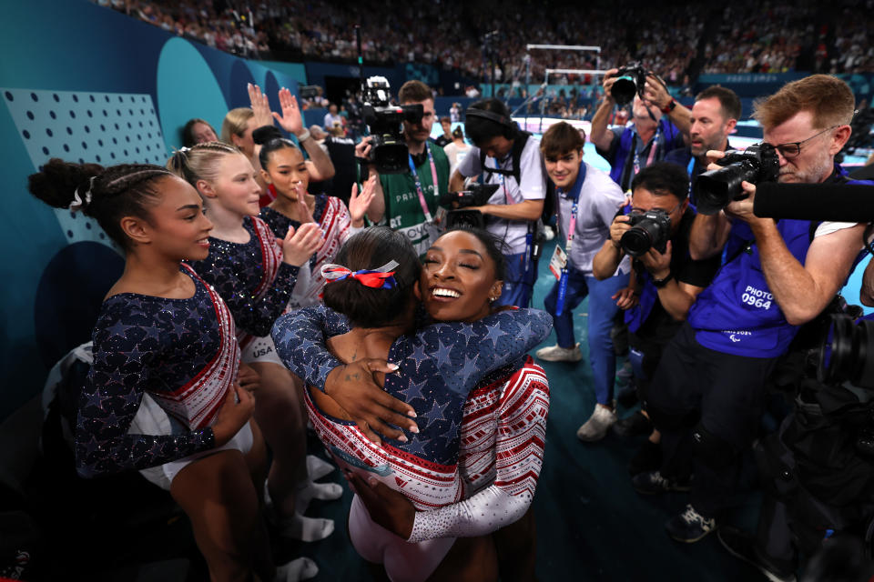 Biles and Chiles hug alongside their teammates after winning gold. 