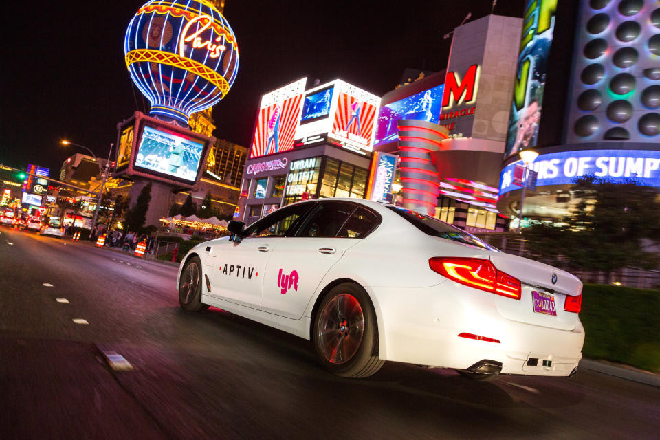 An white BMW driving in Las Vegas with Lyft and Aptiv branding.