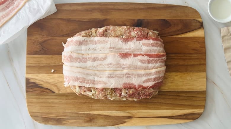 uncooked meatloaf with raw bacon