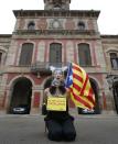 A pro-independence protestor sits in front of Catalonia's regional parliament as lawmakers voted inside, in Barcelona, January 16, 2014. Local lawmakers in the northeastern Spanish region of Catalonia voted to seek a referendum on breaking away from Spain on Thursday, setting themselves up for a battle with an implacably opposed central government in Madrid. The Catalan Parliament in Barcelona voted 87 to 43, with 3 abstentions, to send a petition to the national parliament seeking the power to call a popular vote on the region's future. The independence movement in Catalonia, which has its own language and represents a fifth of Spain's national economy, is a direct challenge to Prime Minister Mariano Rajoy, who has pledged to block a referendum on constitutional grounds. The placard reads, "My name is Catalonia". REUTERS/Albert Gea (SPAIN - Tags: POLITICS CIVIL UNREST)