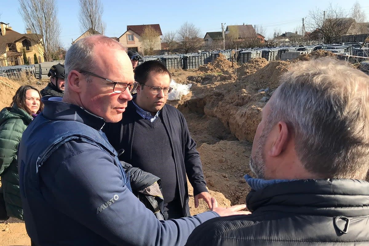 Ireland’s Minister for Foreign Affairs Simon Coveney being shown the site of mass graves in Bucha earlier this year (Department of Foreign Affairs/PA) (PA Media)