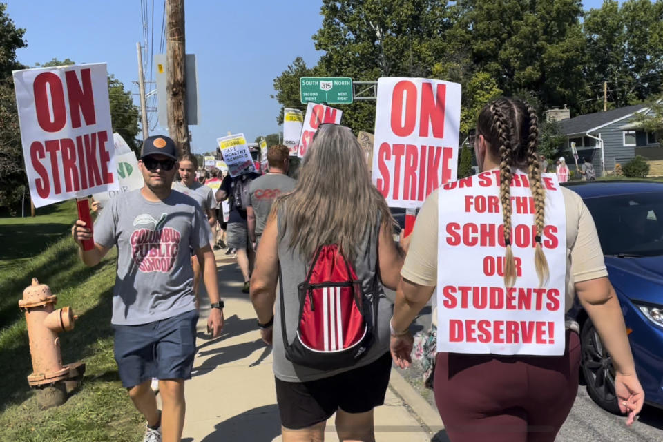 A union member proudly pickets with her homemade sign as part of a district-wide teacher's strike outside Whetstone High School in Columbus, Ohio, on Wednesday, Aug. 24, 2022. A strike by teachers in Ohio's largest school district entered its third day Wednesday — the first day of school for some 47,000 students, with some of those students and their parents rallying to their sides. (AP Photo/Samantha Hendrickson)