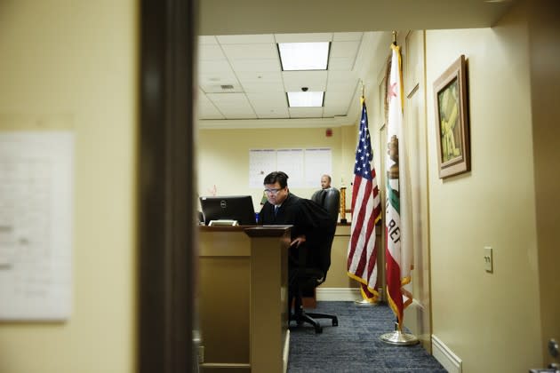 Perez looks over client files during a court session. (Emily Berl / The Atlantic)