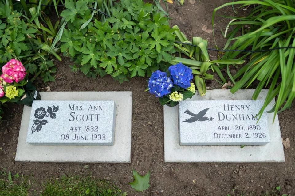 Memorial markers for Ann Scott and Henry Dunham sit freshly decorated with flowers during a dedication at African Cemetery #2 in Lexington, Ky., Saturday, May 21, 2022. Scott and Dunham were relatives of poet Paul Laurence Dunbar.