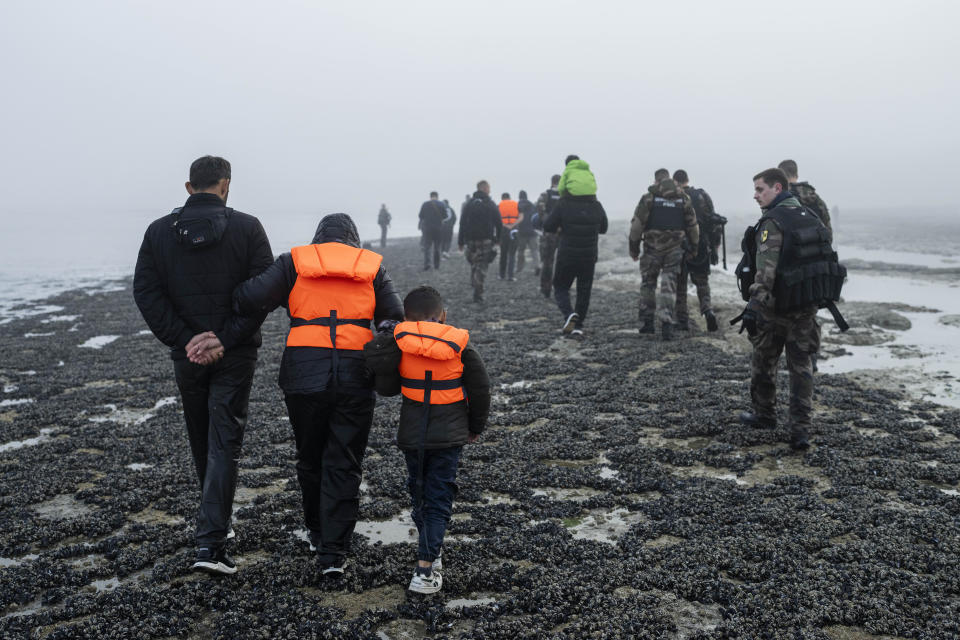 A group of Kurdish migrants from Iran and Iraq who failed in their attempt to reach the United Kingdom by boat walk back to the town of Ambleteuse, in northern France, on Sunday, May 19, 2024 after being discovered by the police. (AP Photo/Bernat Armangue)