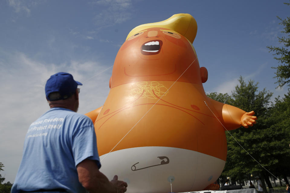 Protester Jim Girvan moves a Baby Trump balloon into position before Independence Day celebrations, Thursday, July 4, 2019, on the National Mall in Washington. (AP Photo/Patrick Semansky)
