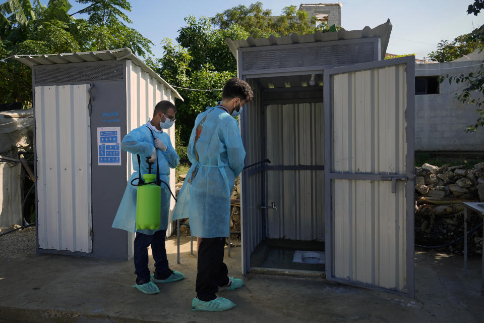 UNICEF health workers sanitize bathrooms as part of their cholera outbreak containment response, at a Syrian refugee camp in Bhanine village, in the northern Akkar province, Lebanon, Tuesday, Oct. 18, 2022. In recent weeks, thousands of cholera cases have swept across the crisis-stricken countries of Lebanon, Syria, and Iraq. The three nations are struggling with depleted health care and water infrastructure, political and economic turmoil, and large populations of refugees and displaced people who live in overcrowded camps. (AP Photo/Bilal Hussein)