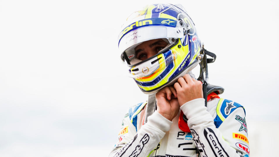 Racer Lando Norris dons his helmet at Autodromo Nazionale di Monza for round 10 of the Formula 2 series  in 2018.