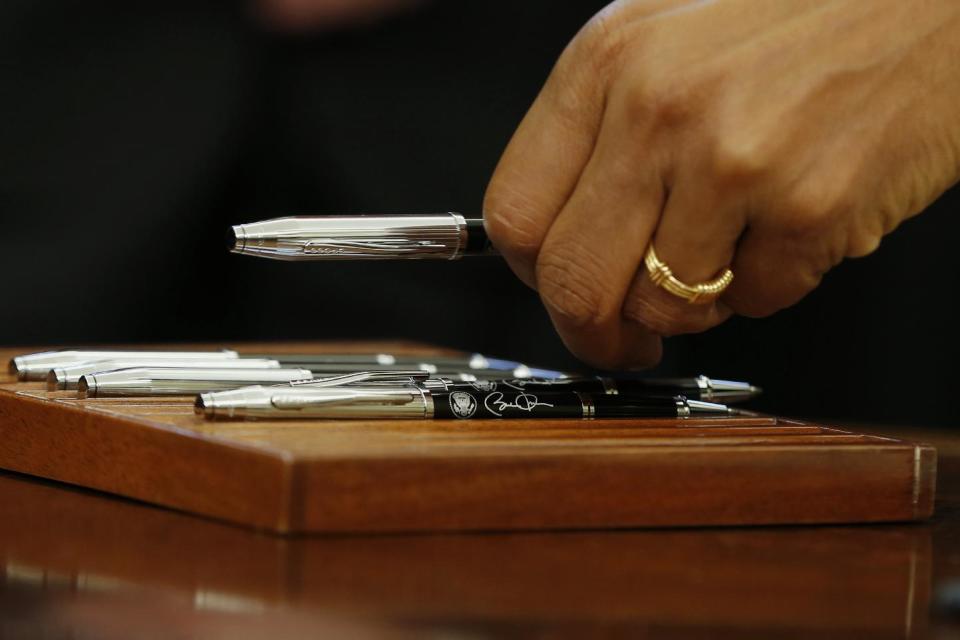 President Barack Obama picks up a personalized pen before signing a document desiganting the Point Arena-Stornetta Public Lands as part of the California Coastal National Monument during a signing ceremony in the Oval Office of the White House in Washington, Tuesday, March 11, 2014. The action will permanently protect some 1,665 acres of federal lands on the Mendocino County coast in Northern California, just north of Point Arena. It will expand a national monument created in 2000 by President Bill Clinton to include coastal bluffs and shelves, tide pools, onshore sand dunes, coastal prairies, riverbanks and the mouth and estuary of the Garcia River. (AP Photo/Charles Dharapak)