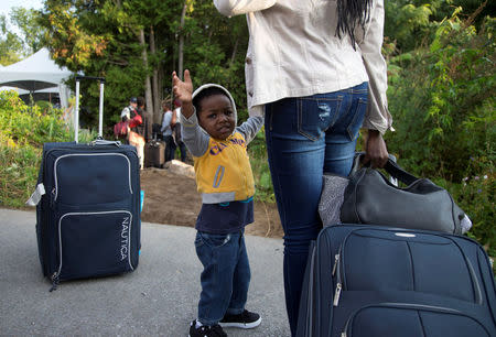 Two-year-old Evanston, whose family stated they are from Haiti, waits to enter into Canada from Roxham Road in Champlain, New York August 11, 2017. REUTERS/Christinne Muschi