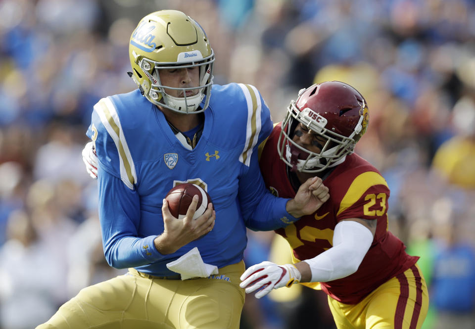 UCLA quarterback Wilton Speight, left, is pressured by Southern California cornerback Jonathan Lockett (23) during the first half of an NCAA college football game Saturday, Nov. 17, 2018, in Pasadena, Calif. (AP Photo/Marcio Jose Sanchez)